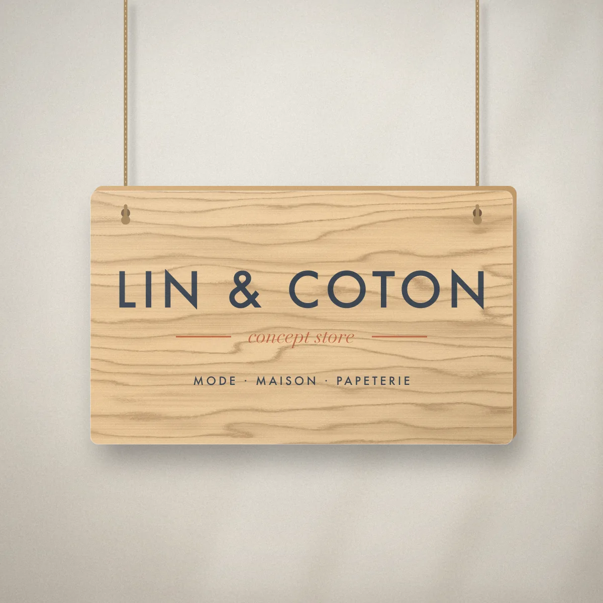 Panneau bois avec logo pour Lin & Coton, concept store fictif, posé derrière le comptoir de la boutique