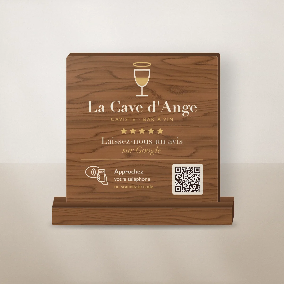 Plaque avis Google bois imprimée en couleur pour La Cave d’Ange, caviste fictif, posée sur un comptoir avec puce NFC et QR code