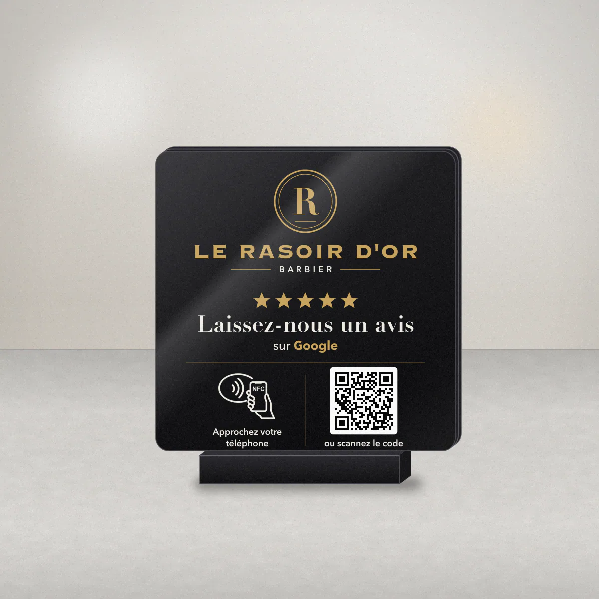 Plaque avis Google en acrylique noir pour un barbier, logo clair de l’enseigne fictive Le Rasoir d’Or et QR code dans un cadre clair